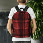 A boy wearing a Backpack in Celtic Red Highland Plaid, can hold up to a 15" Laptop, or Tablet, many pockets for more, Padded Shoulder Strapssturdy, Water Resistant.