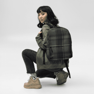 A woman crouching down with a Backpack Celtic Black Plaid.