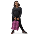 A young girl holding a Backpack Celtic Fucia Pink and Burgundy and Black Highland Plaid, which can hold up to a 15" Laptop, or Tablet, has many pockets for more, and features padded shoulder straps.
