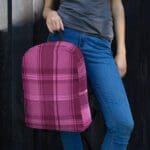 A woman wearing a Backpack Celtic Fucia Pink and Burgundy and Black Highland Plaid, can hold up to a 15" Laptop, or Tablet, many pockets for more, Padded Shoulder Straps.