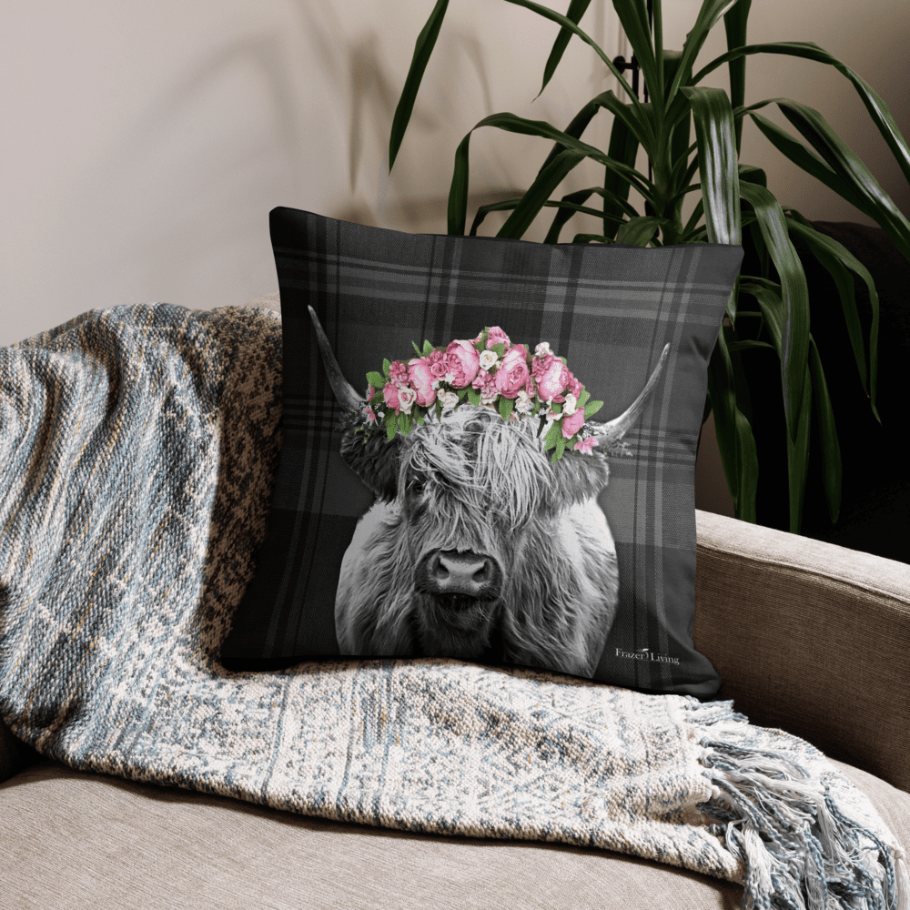 Highland cow with floral crown on pillow.