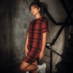 Woman in red plaid dress on stairs.