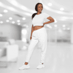 Woman wearing white crop top and sweatpants.