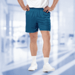 Man wearing blue athletic shorts and white sneakers.