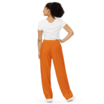 Woman wearing orange pants and white shirt.