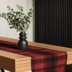 Red and black plaid table runner with vase.