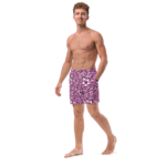 Man wearing pink floral swim trunks.