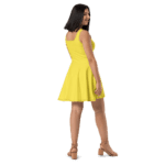 Woman in a yellow sundress looking over shoulder.