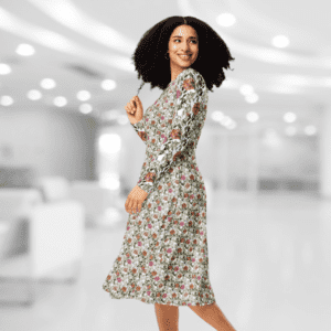 Woman in floral dress smiling in hallway.