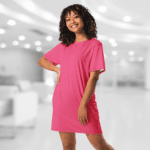 Woman in a pink t-shirt dress smiling.