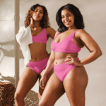 Two women in pink bikinis smiling.