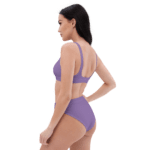 Woman in a purple bikini looking away.