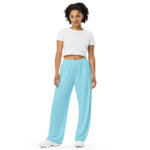 Woman wearing a white crop top and blue pants.