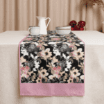 Black floral table runner with pink trim.