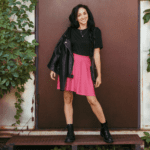 Woman in pink skirt and black boots.