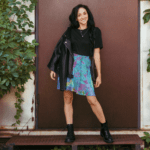 Woman in black shirt and tie-dye skirt.