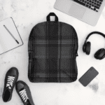 Black plaid backpack with laptop and headphones.