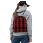 Woman wearing a red plaid backpack.