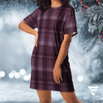 A woman in purple plaid dress standing next to christmas tree.